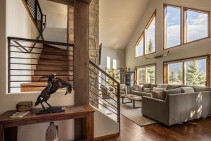 a living room with a couch and a staircase at Southfork Retreat in Big Sky