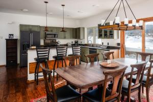a kitchen and dining room with a wooden table and chairs at Southfork Retreat in Big Sky