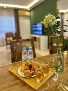 ein Tisch mit einem Teller Gebäck und Wasserflaschen in der Unterkunft Élégance Centrale Face TGV & à 5 min de la Mer in Tangier + 86 Fotos