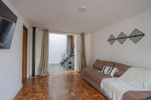 a living room with a couch and a large window at Hermoso duplex en Palermo in Montevideo