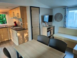 a kitchen and dining room with a table and chairs at La Petite Maison du Park in Boofzheim