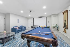 uma sala de estar com uma mesa de bilhar e um ecrã em Luxe Family Escape with Games and Hot Tub and Yard em San Antonio