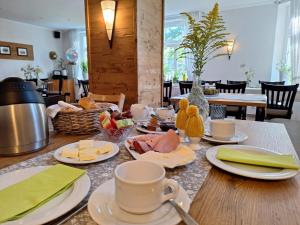 a table with cups and plates of food on it at Pension Kastanienhof in Zeulenroda +17 photos