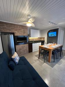 a kitchen and dining room with a table and a couch at Solarium Riviera - Casa2 - NOVA 600m praia Riviera in Matinhos