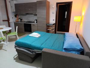 a bedroom with a blue bed and a kitchen at Appartamento Ginger House in Francavilla al Mare +2 photos