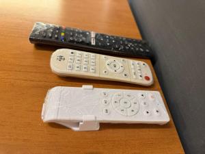 two remote controls sitting on top of a table at Solarium Riviera - Casa2 - NOVA 600m praia Riviera in Matinhos +15 photos