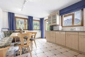 a kitchen and dining room with a table and chairs at Chasa Vaidum by MEIN SAMNAUN - MOUNTAIN HOMES in Samnaun