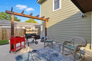 um pátio com cadeiras, uma mesa e comodidades para churrascos em Luxe Family Escape with Games and Hot Tub and Yard em San Antonio