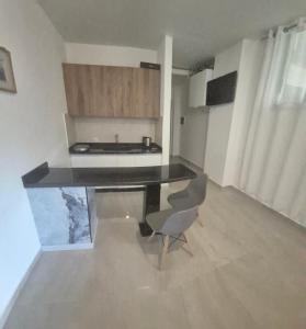 a kitchen with a table and a chair in a room at Aley Pilot Residence in Al Qammāţīyah