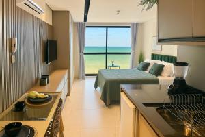 a kitchen and living room with a bed and a view of the ocean at Flat Vista-Mar in Cabedelo