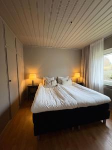 Un dormitorio con una cama grande con dos lámparas. en Centralt hus i Årjäng, en Årjäng