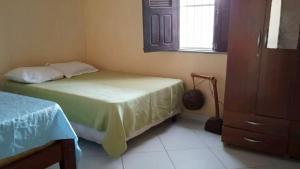 a bedroom with two beds and a window at Casa com 5 suítes e Churrasqueira para 12 pessoas in Atalaia