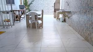 a tile floor in a room with a table and chairs at Casa com 5 suítes e Churrasqueira para 12 pessoas in Atalaia