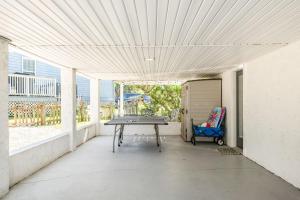 a patio with a ping pong table and a garage at The Sand Euro - 4BR, 3Full & 1Half BA in Historic Summer Haven near beaches and Matanzas Inlet in Summer Haven