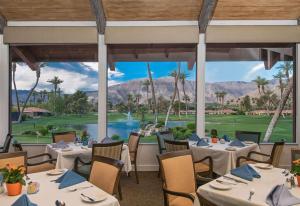 a restaurant with tables and chairs and a view of a golf course at Spectacular View Just Steps to Pool and Jacuzzi at Sunrise Country Club in Rancho Mirage