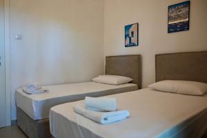 a room with two beds with towels on them at Sani Villa Miramare in Sani Beach