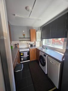 eine kleine Küche mit Waschmaschine und Trockner in der Unterkunft A home in the city in London