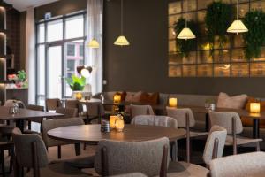 a restaurant with tables and chairs and a couch at Home Hotel Majoren in Skövde