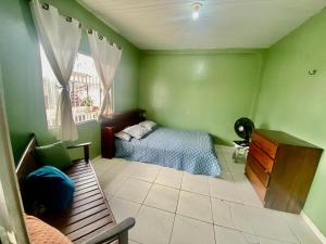a bedroom with a bed and a bench and a window at house for cop30 in val-de-cans in Belém