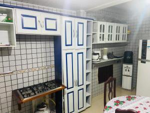 a small kitchen with white cabinets and a stove at house for cop30 in val-de-cans in Belém