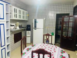 a kitchen with a table and a white refrigerator at house for cop30 in val-de-cans in Belém +7 photos