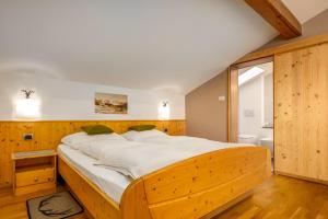 a large wooden bed in a room with a bathroom at Haus Lasaun in Bressanone +117 photos