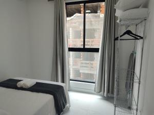 a bedroom with a bed and a window at Estadia completa a 500m do mar em Itapema - STWs in Meia Praia +20 photos