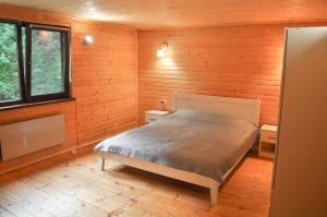 a bedroom with a bed in a wooden cabin at Гостьовий дім Секвойя in Verkhniy Bystryy