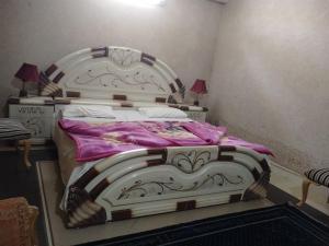 a bedroom with a large bed with pink sheets at Bhurban Apartments Bhurban Murree Pakistan in Murree