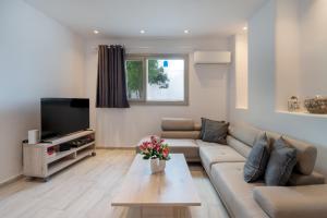 een woonkamer met een bank en een tv bij Marmara Village Home in Mármara