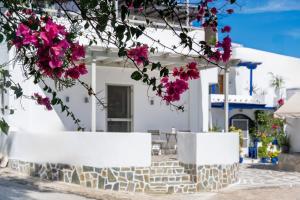 een groep witte gebouwen met roze bloemen bij Marmara Village Home in Mármara