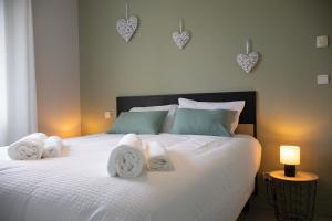 een slaapkamer met een wit bed met handdoeken erop bij Mon havre de paix, Villa Campagne Charentaise in Mansle