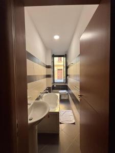 a bathroom with two sinks and a window at La Fenice Central in Reggio Calabria