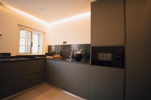 a kitchen with black counter tops and a window at Petit Suite in Valle Gran Rey +18 photos