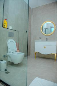 a bathroom with a toilet and a sink and a mirror at Semo's Aqua luxury 6 bedrooms Penthouse sea views in Mombasa