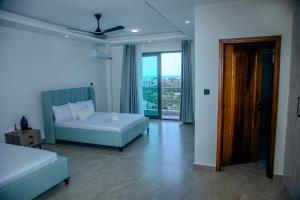 a bedroom with a bed and a chair and a window at Semo's Aqua luxury 6 bedrooms Penthouse sea views in Mombasa +80 photos