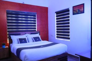 Un dormitorio con una cama grande con una pared roja. en Mountain Vibes Wayanad Pool Villa and Spa, en Wayanad