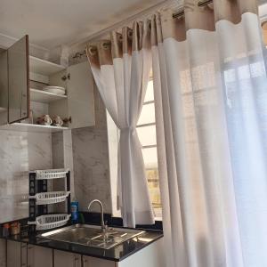 Ongata Rongai にあるFara Luxury homesの窓に白いカーテンがかかったキッチン