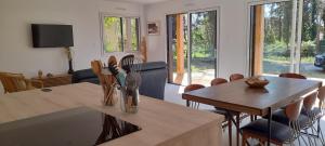 a living room with a wooden table and chairs at Le Petit Bois Vert in Jard-sur-Mer