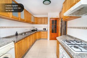 a kitchen with wooden cabinets and a stove top oven at Royal Chic Centre-Ville & Plage à 5 min in Tangier