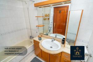 a bathroom with a sink and a mirror and a tub at Royal Chic Centre-Ville & Plage à 5 min in Tangier