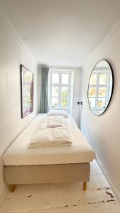 a white bedroom with a bed and a window at Latin Quater 1 - 4 in Copenhagen