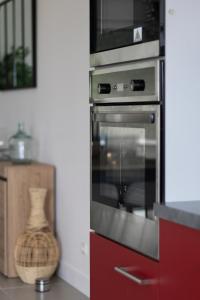 een keuken met een oven en een magnetron bij Mon havre de paix, Villa Campagne Charentaise in Mansle