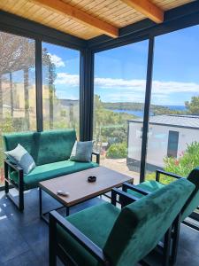 a living room with a couch and chairs and a table at Sea view Anika by Vellaris, Luxury Mobile Home in Mali Lošinj