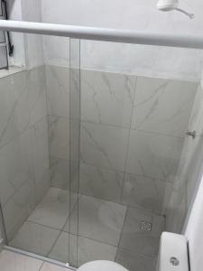 een douche met een glazen deur naast een toilet bij Chácara embaixador in Hortolândia