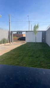 een grasveld met een hek en een boom bij Chácara embaixador in Hortolândia