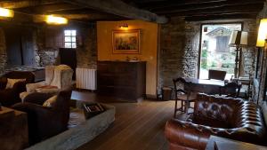 a living room with leather furniture and a table at Casa Berdeal in Mañón