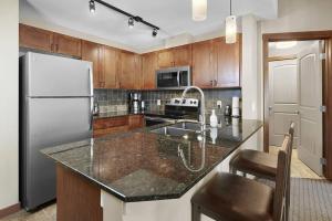 a kitchen with a refrigerator and a counter top at Mountain View Escape with open hot tub, Views!! in Canmore
