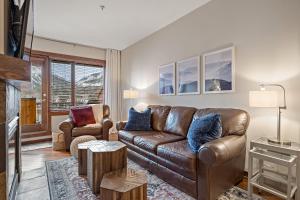 a living room with a brown leather couch and chairs at RidgeView Loft - Top Floor 2 Bed 2 Bath, Amazing Views in Canmore