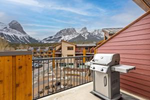 a camera on a balcony with mountains in the background at RidgeView Loft - Top Floor 2 Bed 2 Bath, Amazing Views in Canmore +29 photos